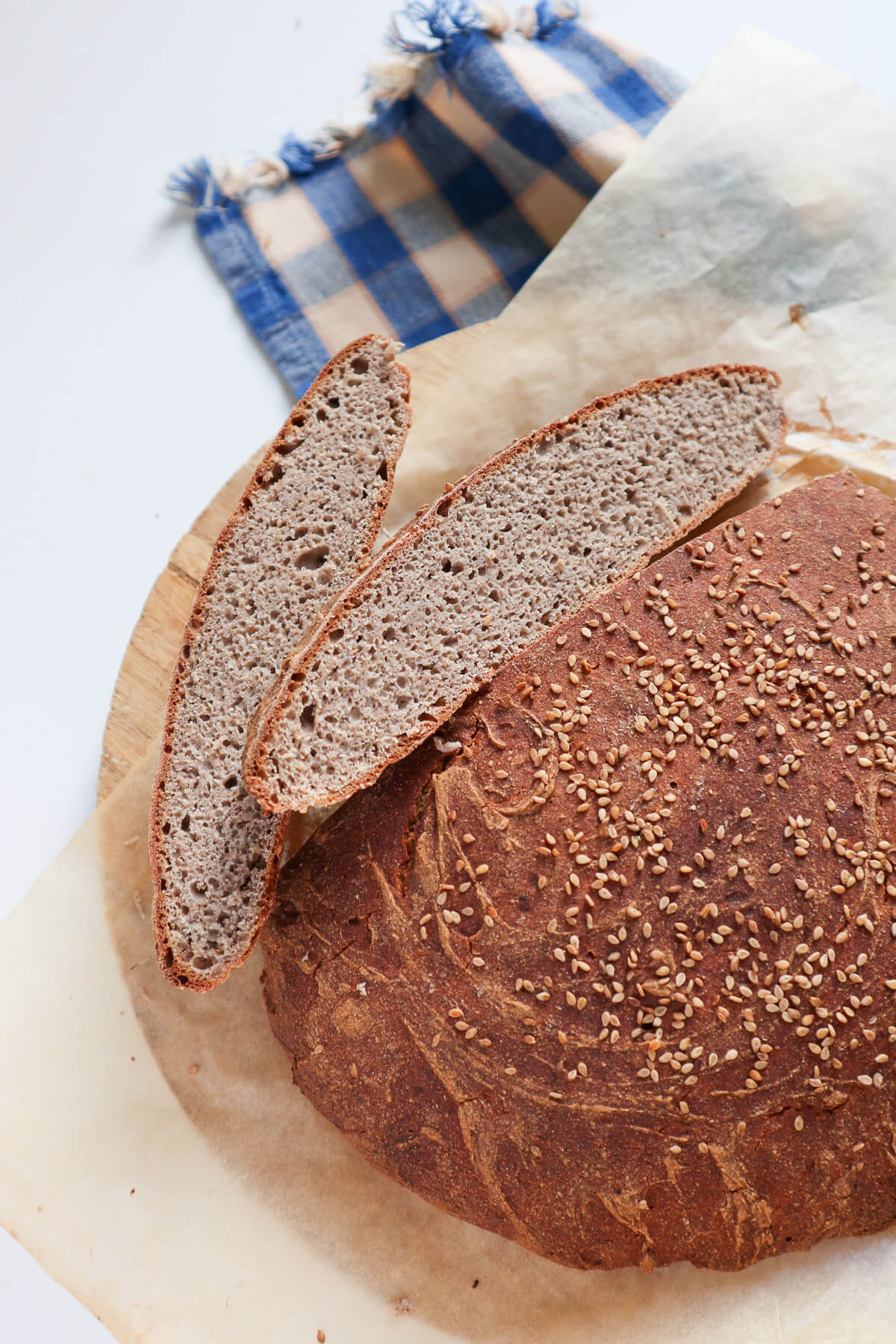 Round artisan looking buckwheat bread with two slices nex to it