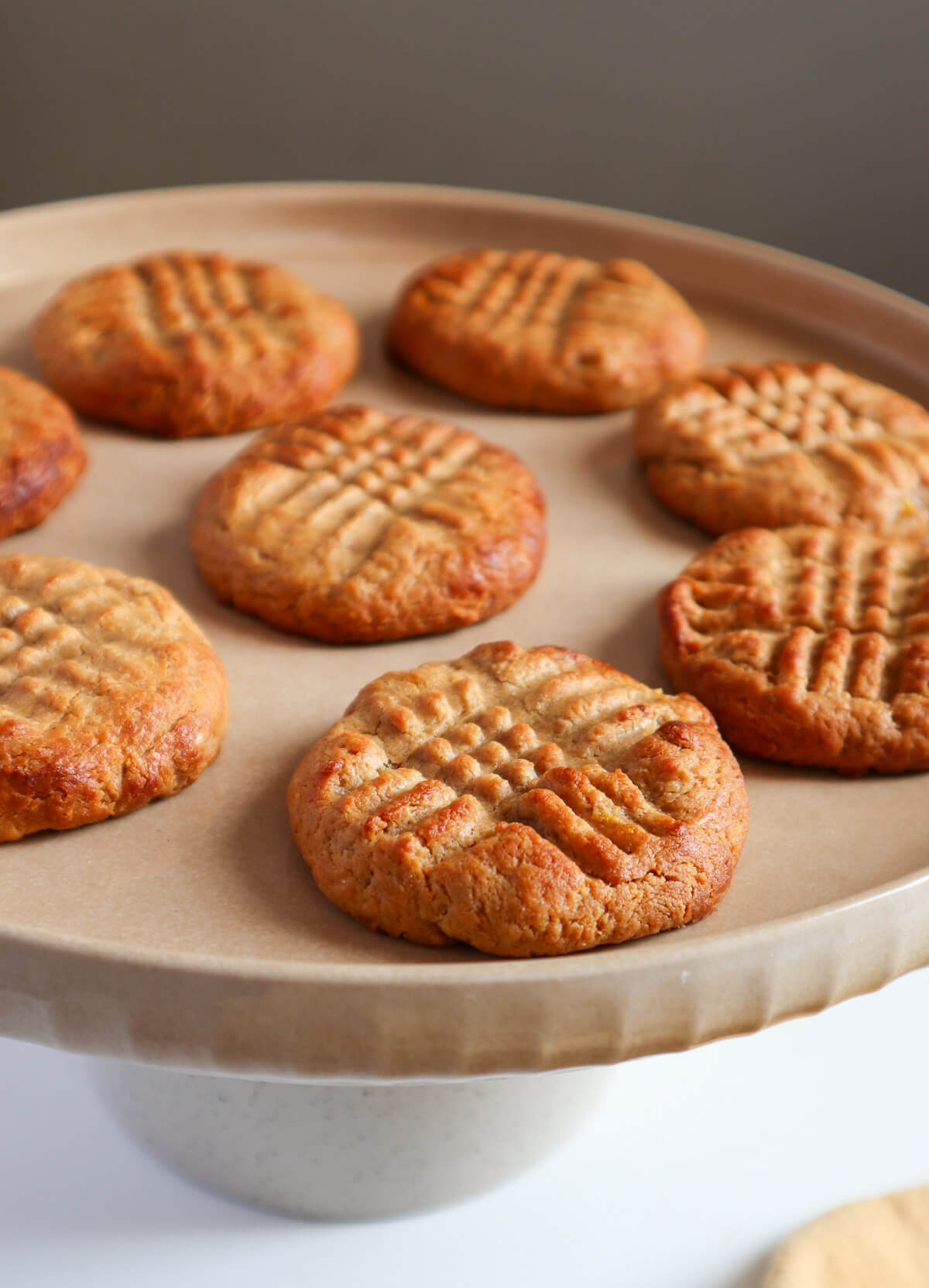Multiple peanut butter cookies on a grey plate